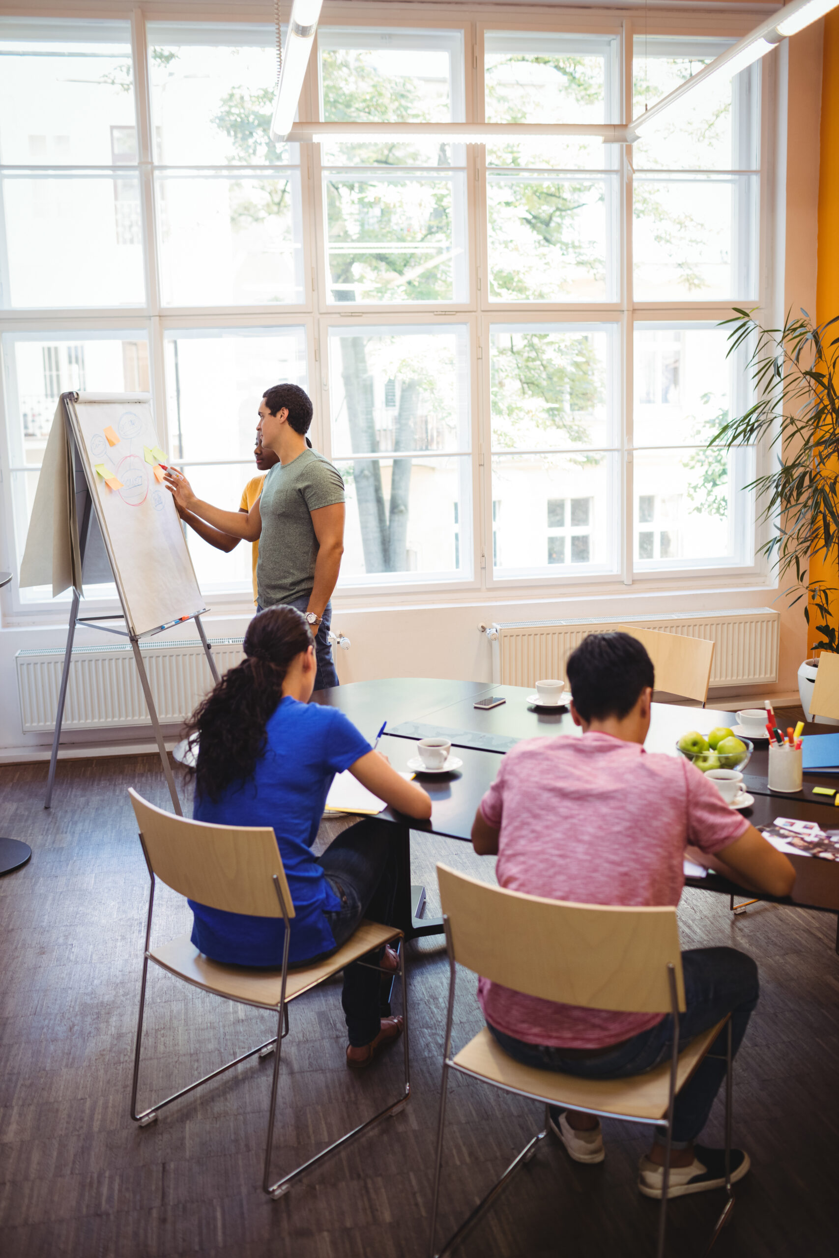 Business executives discussing with their colleagues on whiteboard